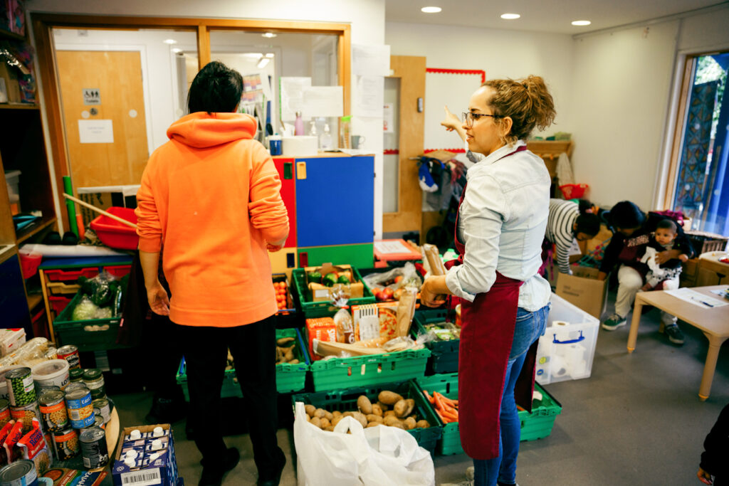 A member of Healthy Living Platform helping a parent at a food pantry